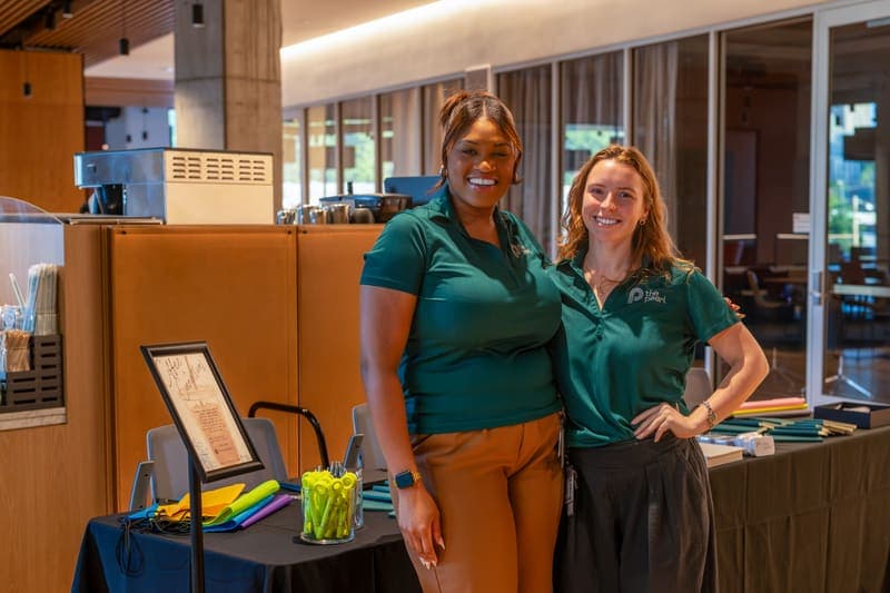Two members of The Pearl team at the Coffee & Connections welcome table in The Assembly